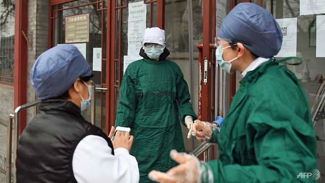 Nhân viên y tế đeo khẩu trang để ngăn chặn lây Covid-19 khi họ trò chuyện bên ngoài một bệnh viện ở Bắc Kinh.