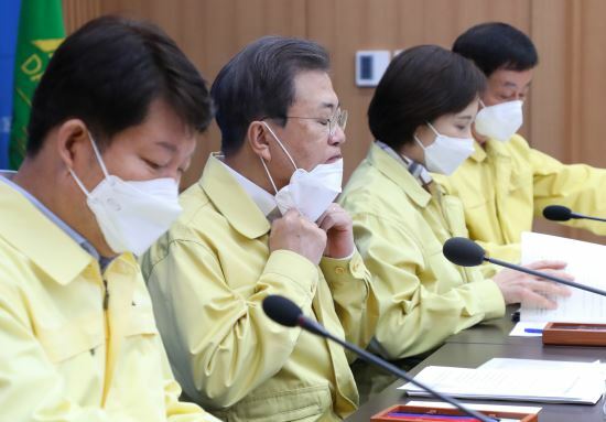 Tổng thống Moon Jae-in (thứ hai từ trái sang) kéo khẩu trang xuống để phát biểu tại cuộc họp về đối phó với dịch Covid-19 tại thành phố Daegu hôm 25/2.
