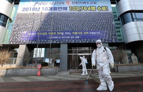 Nhân viên làm vệ sinh trước cổng nhà thờ của giáo phái Tân Thiên Địa ở thành phố Daegu - một trong hai ổ dịch Covid-19 ở Hàn Quốc.