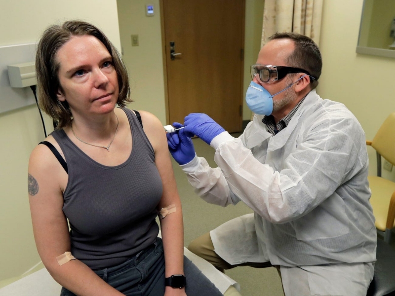 Một dược sĩ tiêm cho tình nguyện viên Jennifer Haller mũi tiêm đầu tiên trong thử nghiệm lâm sàng giai đoạn đầu của vắc-xin Covid-19.