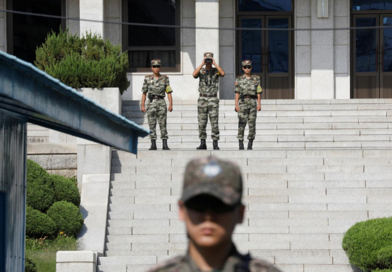 Những người lính Triều Tiên nhìn về phía Nam khi một binh sĩ Hàn Quốc đang đứng gác ở làng đình chiến Panmunjom bên trong khu phi quân sự (DMZ) ngăn cách hai miền hôm 28/8/2019.