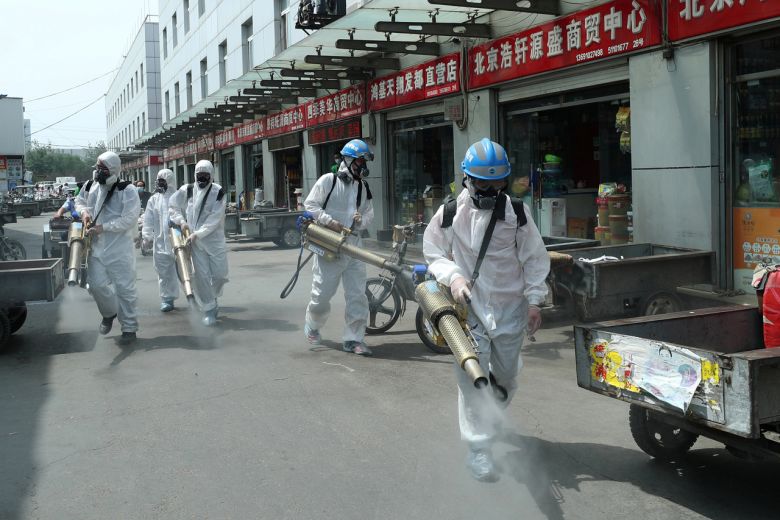 Tin thế giới hôm nay 17/6: Các tình nguyện viên trong bộ đồ bảo hộ khử trùng một chợ ở Bắc Kinh hôm 16/6. Ảnh: REUTERS
