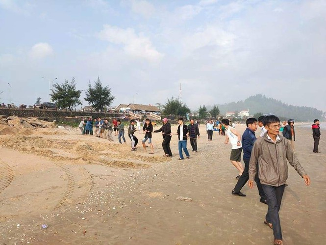 Người dân cùng lực lượng chức năng đang tìm kiếm tung tích hai em học sinh bị sóng cuốn mất tích. Ảnh: Tiền Phong.