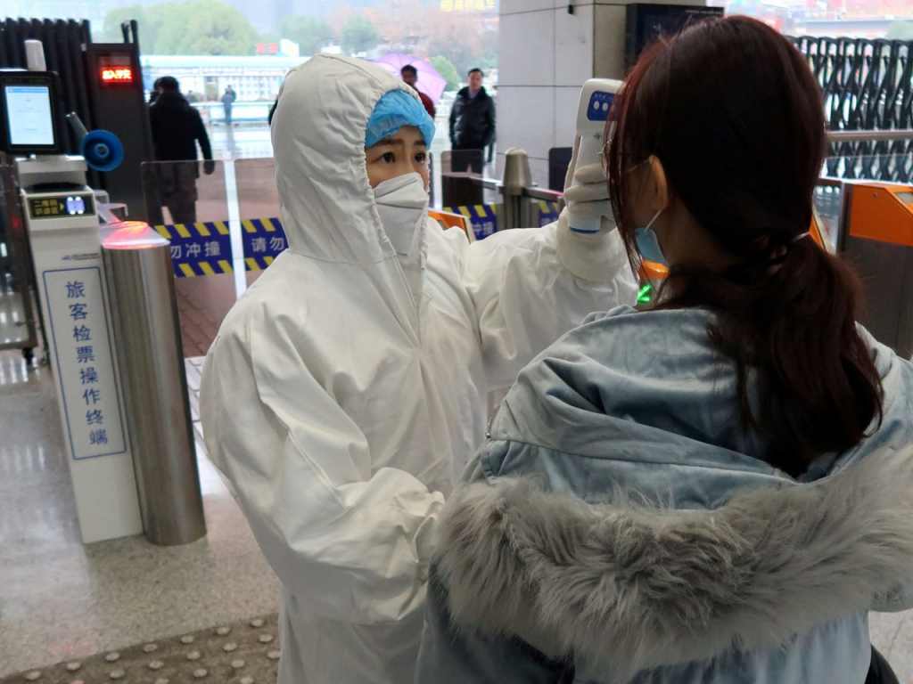Hành khách được kiểm tra nhiệt độ tại một nhà ga ở Trung Quốc.