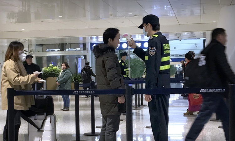 Kiểm tra thân nhiệt tại một sân bay ở Trung Quốc. Ảnh: Reuters
