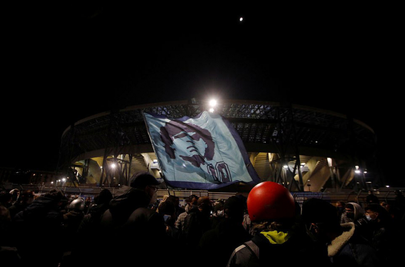 CĐV vẫy cờ in hình Maradona bên ngoài sân vận động của Napoli sau khi hay tin ông qua đời, Ảnh: EPA.