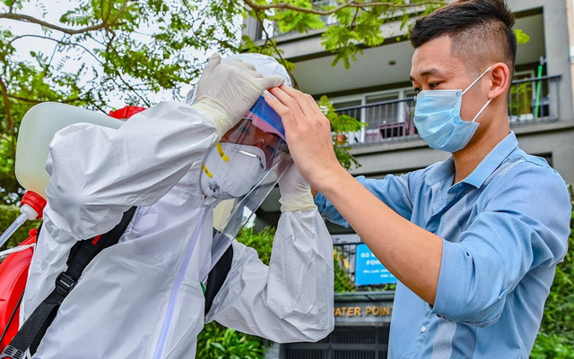  Nhân viên y tế chuẩn bị dụng cụ phun khử khuẩn tại khu vực dân cư có ca mắc COVID-19. Ảnh: Việt Linh
