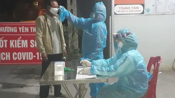 Đo thân nhiệt cho người ra vào tại chốt kiểm dịch ở Quảng Ninh - Ảnh: Bộ Y tế