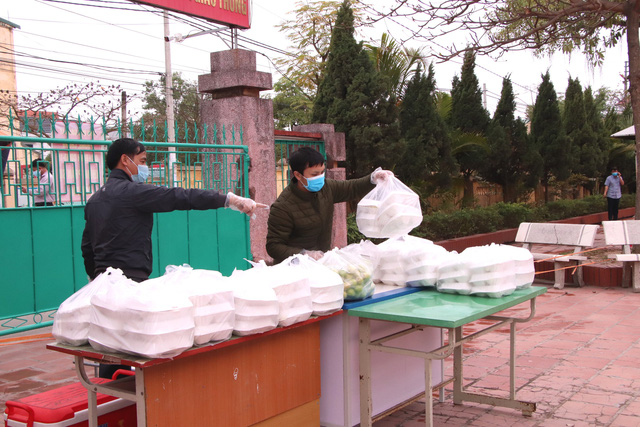  Nhân viên chuyển cơm vào khu cách ly tập trung tại điểm cách ly trường THCS Lai Cách (huyện Cẩm Giàng). Ảnh: Đ.Tùy