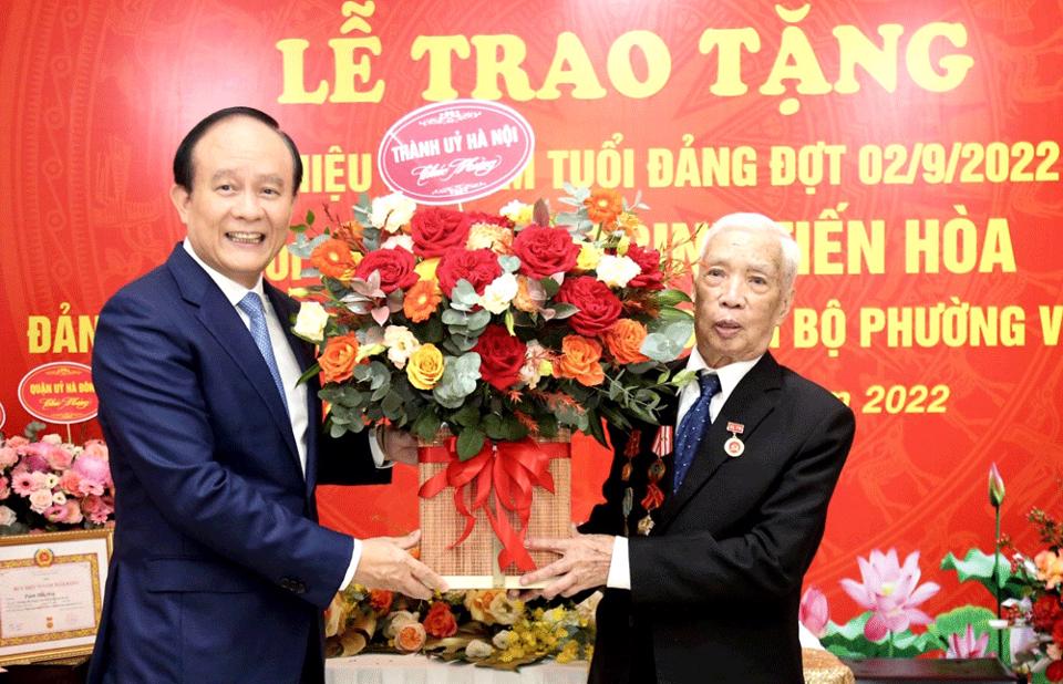  Phó Bí thư Thành ủy, Chủ tịch HĐND TP Nguyễn Ngọc Tuấn tặng hoa và chúc mừng đảng viên lão thành Trịnh Tiến Hòa được trao tặng Huy hiệu 75 năm tuổi Đảng