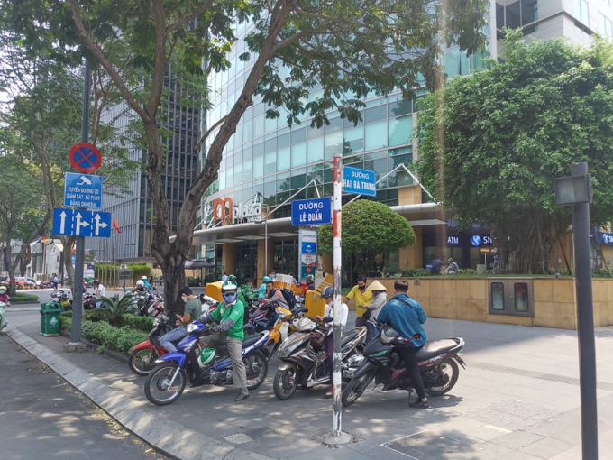 Trước cửa Khu phức hợp Mplaza Saigon, số 39 đường Lê Duẩn, phường Bến Nghé, quận 1, TP.HCM xe ôm, xe công nghệ vẫn tụ tập đông người, đón trả khách như chưa có chuyện gì xảy ra.