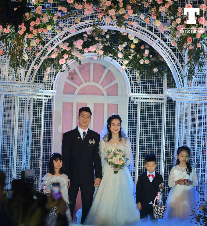 Khoảng 10h30 sáng 9/2, chú rể Duy Mạnh và cô dâu Quỳnh Anh tiến vào hôn trường tại sân bóng thôn Giao Tác trong sự chứng kiến của hàng nghìn người.