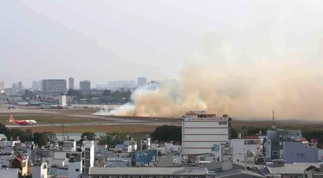 Sự cố khiến đám cỏ ở sân bay Tân Sơn Nhất bốc cháy tạo thành cột khói.