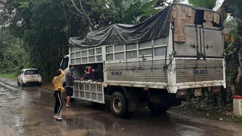 Chiếc xe tải chở 14 người trốn trong thùng xe để né trạm kiểm soát. Ảnh Thanh Niên.