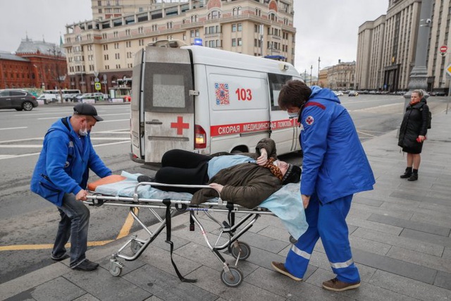 Nhân viên y tế đưa một cụ bà từ trạm xe buýt tới bệnh viện ở Moscow, Nga hôm 17/4 (Ảnh: EPA-EPE).