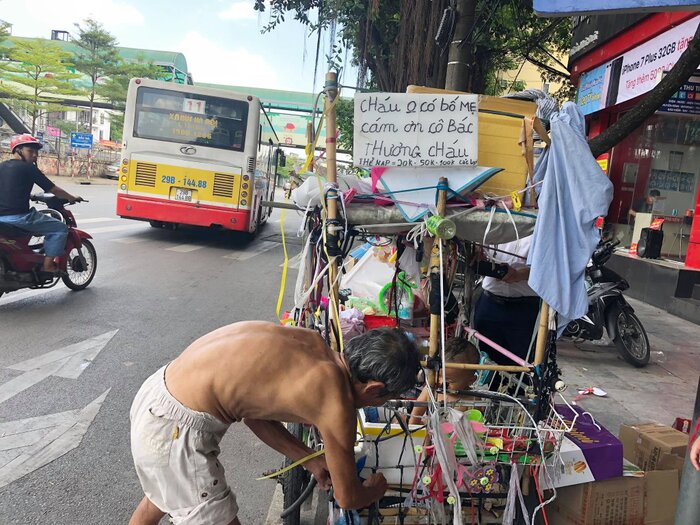 Cháu bé cùng chiếc xe đẩy lang thang ở đường phố Hà Nội cùng tấm biển “cháu không có bố mẹ, cảm ơn cô bác đã thương cháu”.