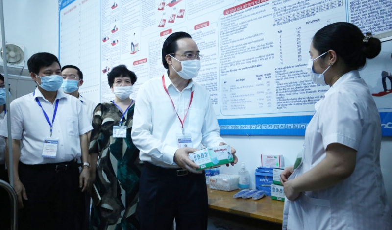 Bộ trưởng trao đổi với nhân viên y tế về các trang thiết bị dự phòng cho kỳ thi tại Trường THCS Nam Từ Liêm (Hà Nội).