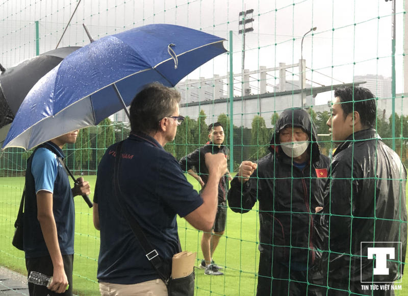 HLV Philippe Troussier cũng đội mưa ra sân theo dõi thầy trò HLV Park Hang-seo tập luyện từ bên ngoài hàng rào.