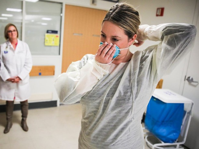 Tình hình dịch Covid-19 thế giới: Một bác sĩ hướng dẫn cách đeo khẩu trang đúng cách tại Bệnh viện Massachusetts (Boston) ngày 27/2. Ảnh: REUTERS