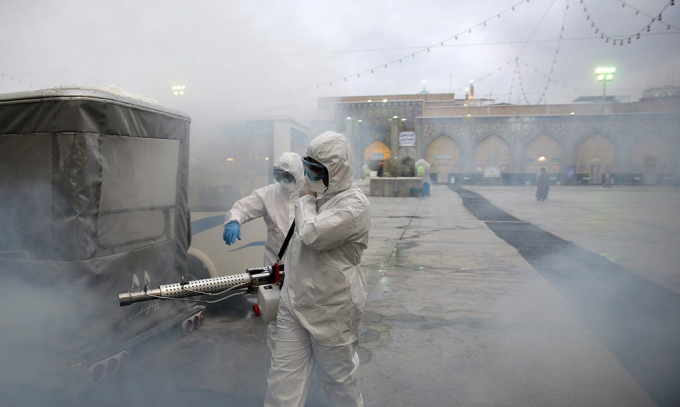 Đội khử trùng làm việc ở Mashhad, Iran. Ảnh: Reuters.