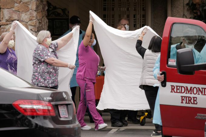 Nhân viên y tế vận chuyển 1 bệnh nhân trên cáng ra xe cứu thương tại một viện dưỡng lão ở Kirkland, Washington, Mỹ hôm Chủ Nhật (15/3). Ảnh: Reuters.