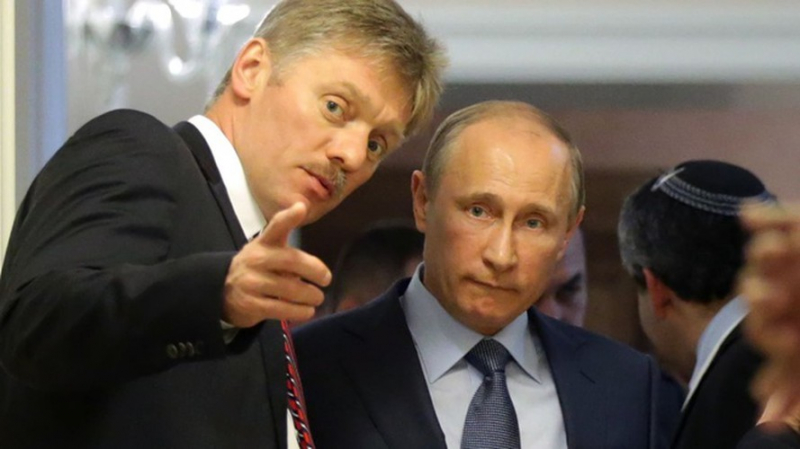 Thư ký báo chí của Tổng thống Nga Dmitry Peskov đứng bên cạnh lãnh đạo của mình.