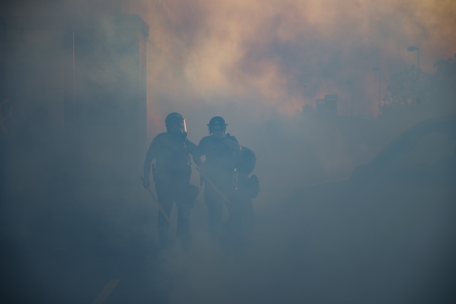 Cảnh sát bước đi trong làn khói mù khí ga ở St. Paul. Ảnh: AP Photo/John Minchillo
