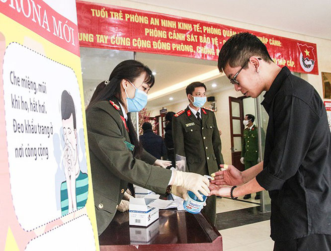 Công an thành phố Hà Nội giúp công dân sử dụng nước sát khuẩn rửa tay vào sáng 10-2.