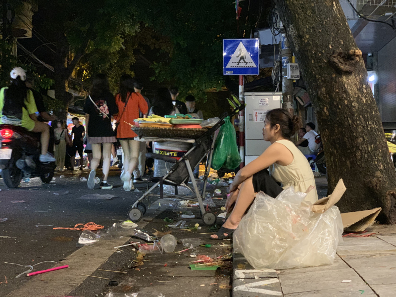 Hàng chưa bán hết hết, nhiều người vẫn ngồi bên cạnh đống rác nhựa do người đi đường bỏ lại. 