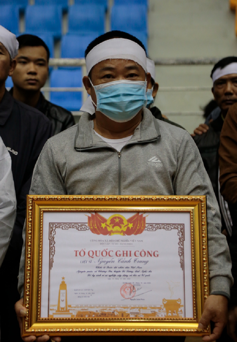Người thân mang theo tấm bằng Tổ quốc ghi công cho liệt sĩ Nguyễn Cảnh Trung.