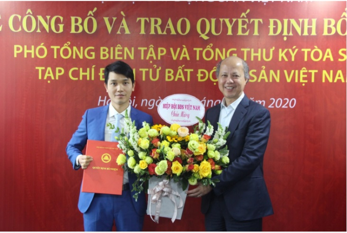 Ông Nguyễn Trần Nam, Chủ tịch Hiệp hội Bất động sản Việt Nam trao quyết định và tặng hoa Nhà báo Bùi Văn Khương.