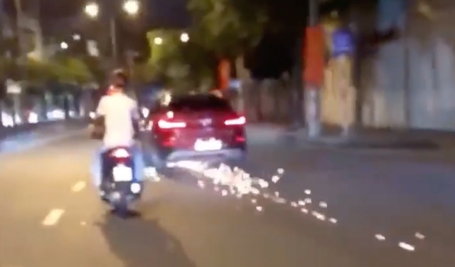 Ô tô BMW cuốn xe máy vào gầm gây tóe lửa trên mặt đường khi bỏ chạy.