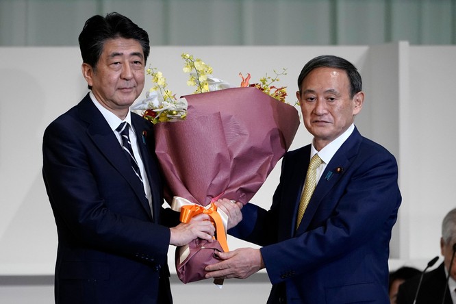 Ông Abe tặng hoa ông Suga sau cuộc bỏ phiếu ngày 14/9 (Ảnh: Reuters)