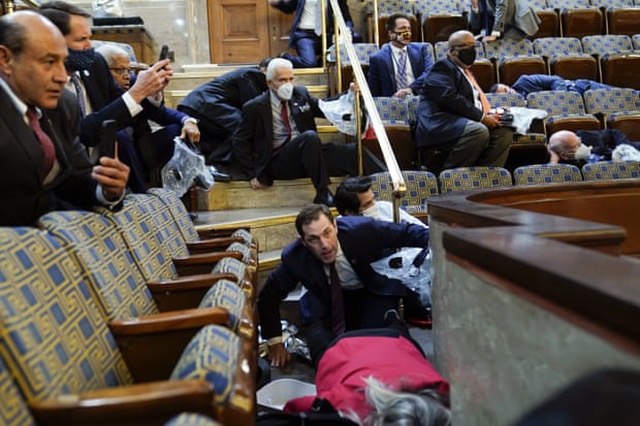 Các nghị sĩ cúi người tìm nơi trú ẩn khi người biểu tình xông vào tòa nhà quốc hội (Ảnh: AP)