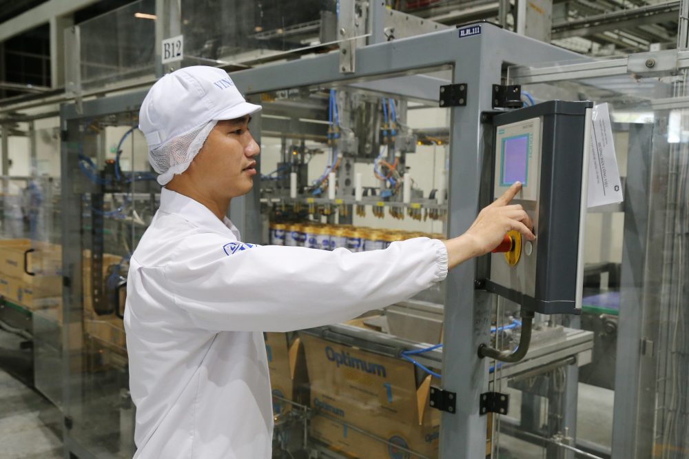 Nhân viên điều khiển dây chuyền tự động tại siêu nhà máy sữa tại Bình Dương.