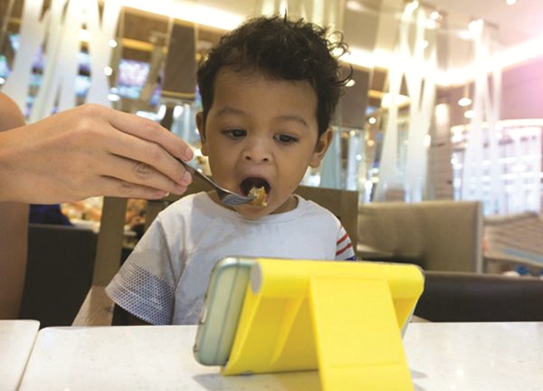 Nhiều phụ huynh sử dụng smartphone để dỗ dành trẻ khi ăn.