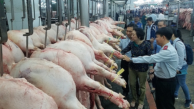 Lực lượng chức năng TPHCM kiểm tra nguồn gốc thịt lợn tại chợ đầu mối Hóc Môn. Ảnh: Minh Trí  