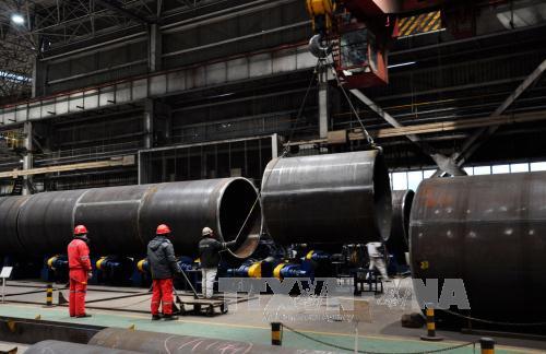 Công nhân làm việc tại nhà máy sản xuất ống thép ở Sơn Đông, Trung Quốc ngày 31/1. Ảnh: AFP/TTXVN