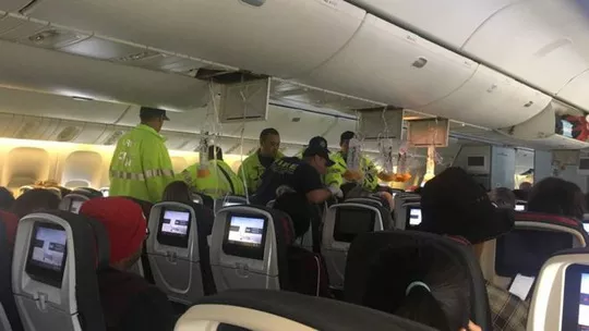 Nhân viên cứu hộ trên chiếc Boeing 777-200LR gặp sự cố nhiễu động. Ảnh: Reuters    