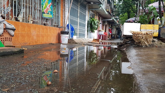 Sau một trận mưa, nước đọng lênh láng trên lối đi vào nhà dân chung cư.    