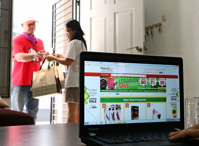 Một phụ nữ nhận hàng mua sắm qua mạng ở Jakarta-Indonesia Ảnh Nikkei Asian Review