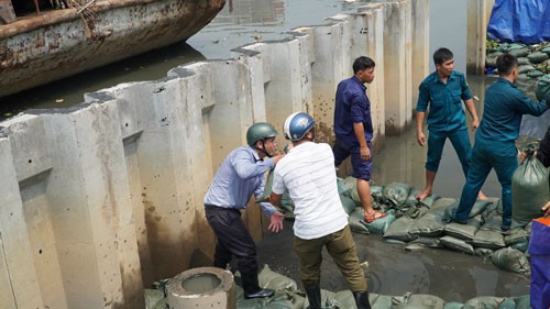 Lực lượng chức năng quận 8, TP HCM gia cố tạm thời bờ bao khu vực cầu kênh Ngang Ảnh: Lê Phong