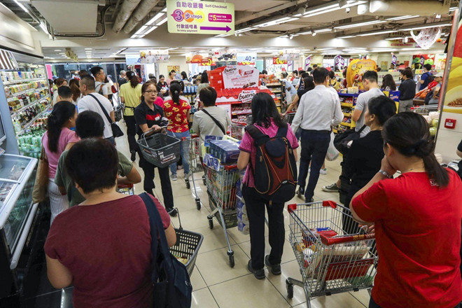 Mọi người đổ xô đến cửa hàng siêu thị Wellcome để dự trữ thực phẩm khi những người biểu tình tiếp tục gây hỗn loạn trong thành phố. Ảnh: SCMP.