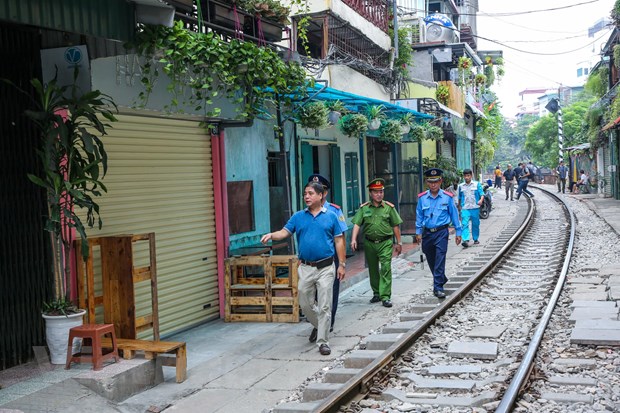 Lực lượng chức năng đang tiến hành kiểm tra, rà soát tại khu vực đường ray tàu hỏa dọc phố Phùng Hưng. (Ảnh: Minh Sơn/Vietnam+)  