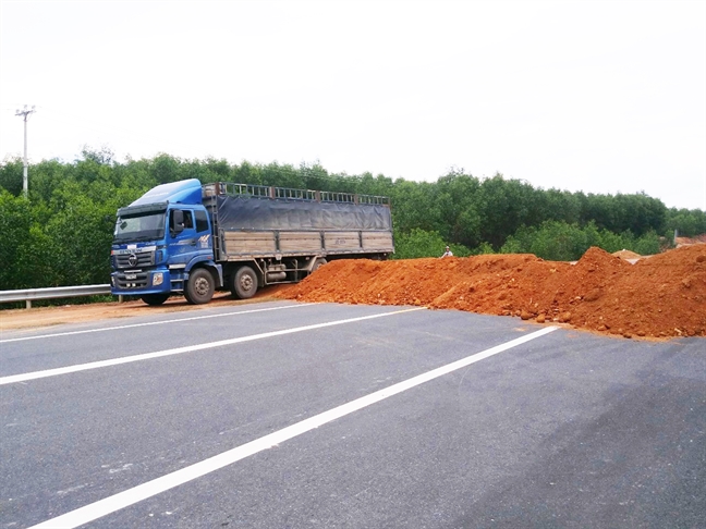 Xe tải và xe khách ngang nhiên chạy vào đường cao tốc La Sơn - Túy Loan bất chấp những bức tường đất và biển báo