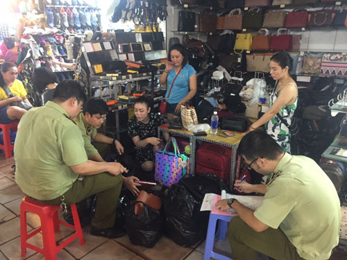Lực lượng QLTT TP HCM xử lý hàng giả, hàng nhái tại chợ Bến Thành (TP HCM) Ảnh: NGUYỄN HẢI