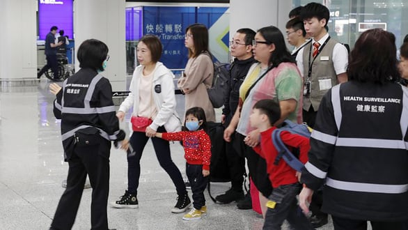 Dùng thiết bị đo kiểm tra sức khỏe và kiểm tra thân nhiệt hành khách trước các quầy làm thủ tục nhập cảnh tại sân bay quốc tế ở Hong Kong - Ảnh: AP