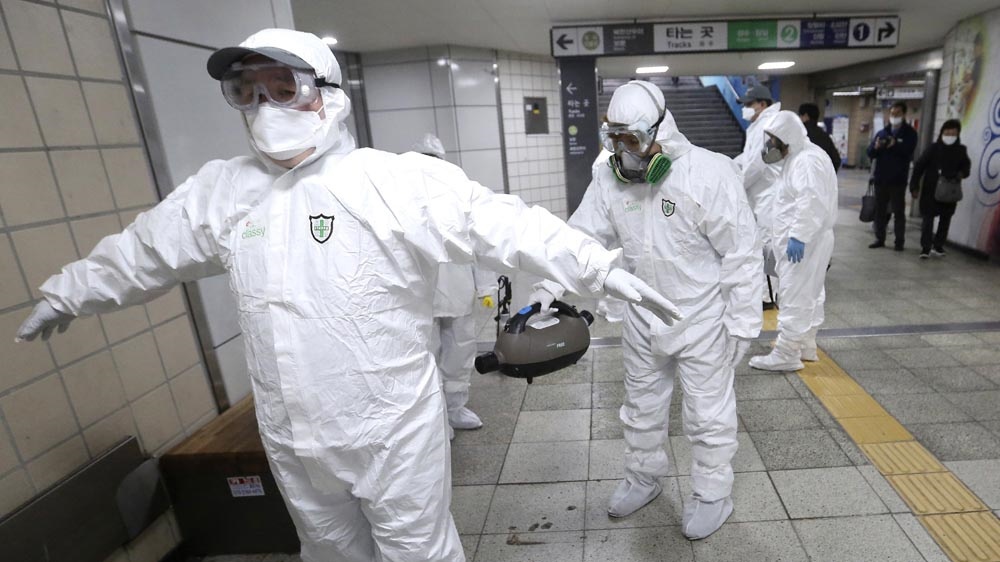 Công nhân mặc đồ bảo hộ làm sạch trang phục của nhau sau khi khử trùng để đề phòng virus corona tại ga tàu điện ngầm ở Seoul, Hàn Quốc. Ảnh: AP.