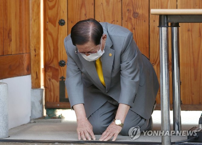 Ông Lee Man-hee quỳ gối trong cuộc họp báo ngày 2/3. Ảnh: Yonhap 