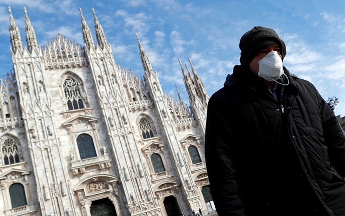 Người đàn ông đeo khẩu trang khi đi qua nhà thờ Duomo tại Milan, Italy, ngày 4-3. (Ảnh: Reuters)